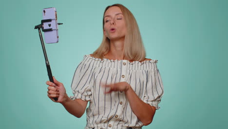 Girl-blogger-take-selfie-on-mobile-phone-selfie-stick-communicate-video-call-online-with-subscribers