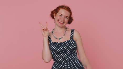 Redhead-young-woman-showing-victory-sign,-hoping-for-success-and-win,-doing-peace-gesture,-smiling