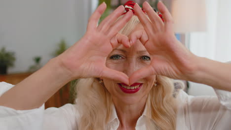 Senior-grandmother-woman-makes-symbol-of-love-showing-heart-sign-to-camera-express-romantic-feelings