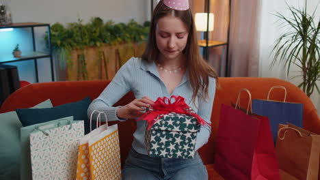Happy-young-woman-hold-birthday-gift-box-with-ribbon,-celebrating-party,-opening-present-at-home