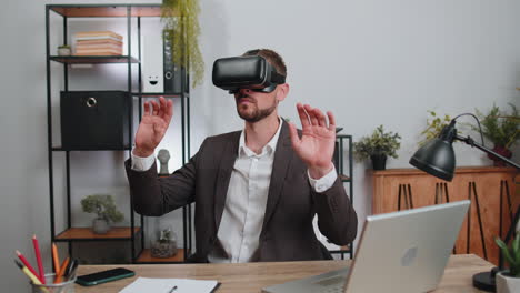 Businessman-working-using-virtual-reality-futuristic-technology-VR-app-headset-helmet-at-home-office