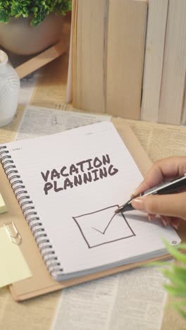 VERTICAL-VIDEO-OF-TICKING-OFF-VACATION-PLANNING-WORK-FROM-CHECKLIST