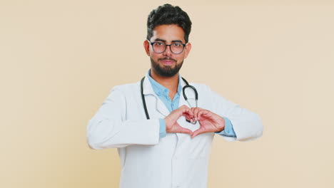 Smiling-doctor-man-makes-heart-gesture-demonstrates-love-sign-expresses-good-feelings-and-sympathy