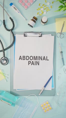 VERTICAL-VIDEO-OF-ABDOMINAL-PAIN-WRITTEN-ON-MEDICAL-PAPER