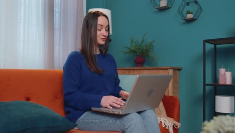 Woman-freelance-wear-headphone-make-video-call-teaching-tutoring-talking-on-laptop-at-home-office