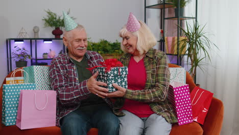 Glückliche-Alte-Seniorenfamilie-Großeltern-Mann-Frau-Feiert-Geburtstag-Jahrestag-Auf-Der-Couch-Zu-Hause