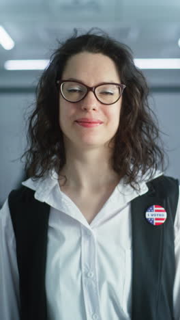 Woman-in-camouflage-uniform-stands-in-polling-station-and-looks-at-camera.-Portrait-of-female-soldier,-United-States-of-America-elections-voter.-Background-with-voting-booths.-Concept-of-civic-duty.