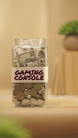 VERTICAL-VIDEO-OF-PERSON-SAVING-MONEY-FOR-GAMING-CONSOLE