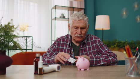 Upset-senior-grandfather-man-examines-last-pills-prescribed-by-doctor-no-money-to-buy-drugs-medicine