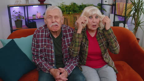 Funny-old-senior-man-woman-making-playful-silly-facial-expressions,-fooling-around,-showing-tongue