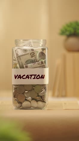 Vertikales-Video-Einer-Person,-Die-Geld-Für-Den-Urlaub-Spart