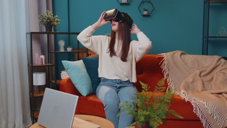 Junge-Frau-Nutzt-Zu-Hause-Eine-Virtual-Reality-Headset-Brille-Und-Genießt-Das-Videokonzept,-Indem-Sie-Hände-In-Der-Luft-Bewegt