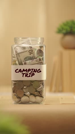 VERTICAL-VIDEO-OF-PERSON-SAVING-MONEY-FOR-CAMPING-TRIP