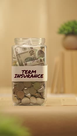 VERTICAL-VIDEO-OF-PERSON-SAVING-MONEY-FOR-TERM-INSURANCE