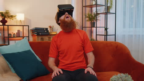 Man-using-virtual-reality-futuristic-technology-headset-to-play-simulation-3D-video-game-at-home