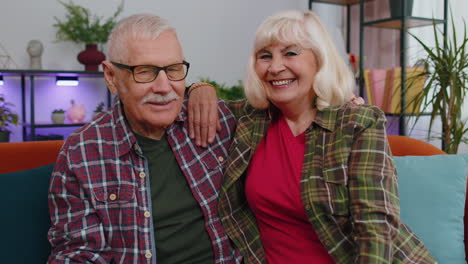Happy-senior-family-couple-grandparents-man-woman-looking-at-camera-demonstrating-keys-from-new-flat