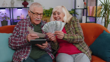 Glückliche-Reiche-Seniorenfamilie,-Großeltern,-Mann-Und-Frau,-Die-Geld-Zählen-Und-Mit-Finanzen,-Haushaltsrechnungen-Und-Papieren-Beschäftigt-Sind