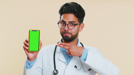 Indischer-Arzt-Hält-Smartphone-Mit-Greenscreen-Chroma-Key-Modell,-Empfiehlt-Gute-Anwendung