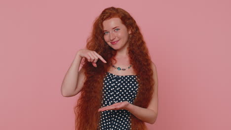 Redhead-woman-pointing-down,-saying-to-subscribe,-gesturing-ok,-like,-showing-place-for-information
