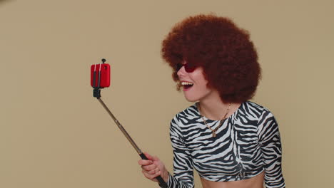 Woman-traveler-blogger-taking-selfie-on-mobile-phone-selfie-stick,-communicating-video-call-online