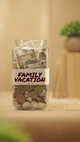 Vertikales-Video-Einer-Person,-Die-Geld-Für-Den-Familienurlaub-Spart