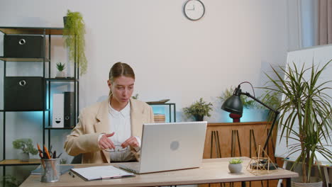 Businesswoman-freelancer-enters-office-workplace,-working-on-laptop-computer,-sends-online-messages