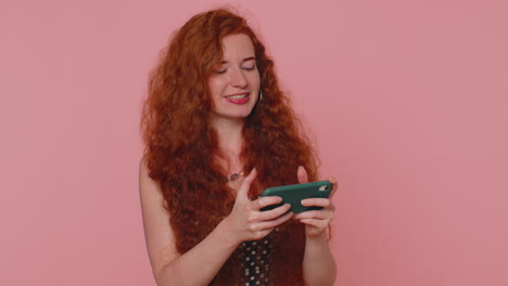 Worried-funny-addicted-redhead-girl-enthusiastically-playing-drive-racing-video-game-on-mobile-phone