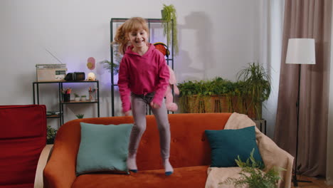 Funny-young-child-girl-kid-dancing-trendy-social-media-dance-while-listening-to-the-music-at-home