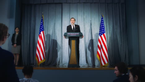 President-of-USA-answers-journalists-questions-and-gives-interview.-Confident-American-republican-politician-delivers-successful-speech-to-supporters-at-press-conference.-Backdrop-with-American-flags.