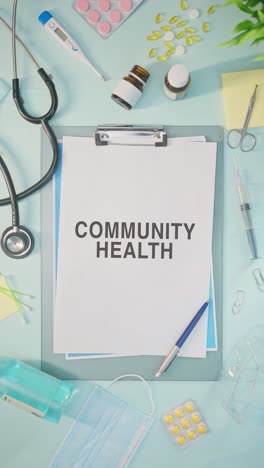 VERTICAL-VIDEO-OF-COMMUNITY-HEALTH-WRITTEN-ON-MEDICAL-PAPER