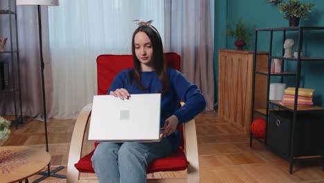 Kaukasische-Junge-Frau-Sitzt-Auf-Dem-Sofa-Und-öffnet-Den-Laptop-PC-Und-Beginnt-Mit-Der-Online-Arbeit-Im-Wohnzimmer-Zu-Hause