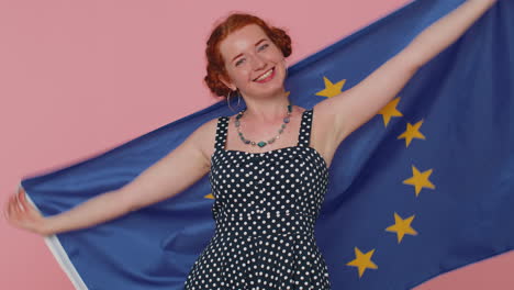 Frau-Im-Gepunkteten-Kleid-Schwenkt-Die-Flagge-Der-Europäischen-Union,-Lächelt-Und-Jubelt-Demokratischen-Gesetzen-Und-Menschenrechten-Zu