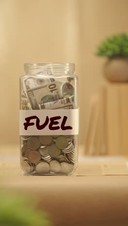 VERTICAL-VIDEO-OF-PERSON-SAVING-MONEY-FOR-FUEL