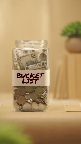 VERTICAL-VIDEO-OF-PERSON-SAVING-MONEY-FOR-BUCKET-LIST