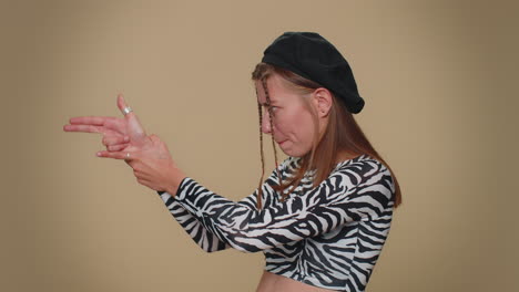 Pretty-confident-girl-pointing-around-with-finger-gun-gesture,-making-choice,-shooting-killing