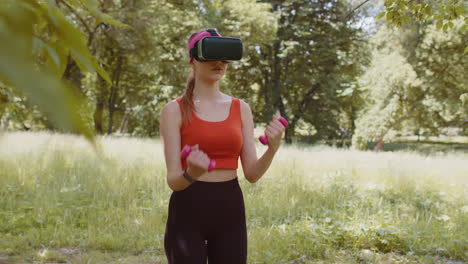 Sportliches-Mädchen-Mit-VR-Headset-Helm-Macht-Fitness-Workout-Übungen-Mit-Hanteln-Im-Freien-Im-Park