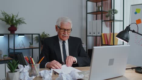 Senior-business-office-man-use-laptop-throwing-crumpled-paper,-having-nervous-breakdown-at-work