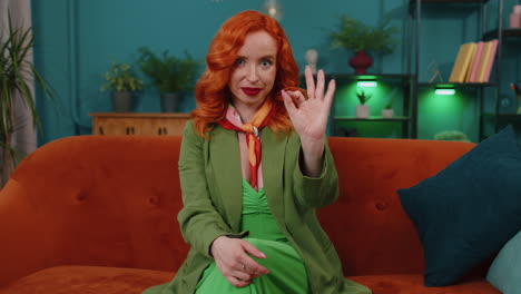 Happy-cheerful-redhead-woman-looking-approvingly-at-camera-showing-ok-gesture,-positive-like-sign