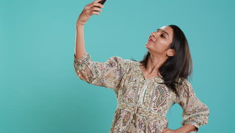 Cheerful-woman-using-smartphone-to-take-selfies