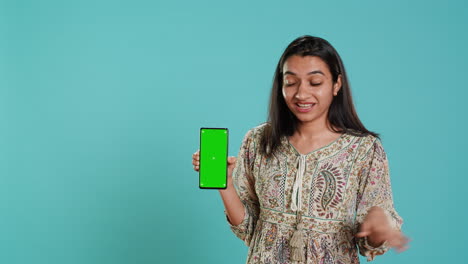 Woman-doing-influencer-marketing-using-green-screen-smartphone