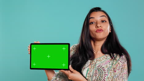 Happy-woman-presenting-green-screen-tablet