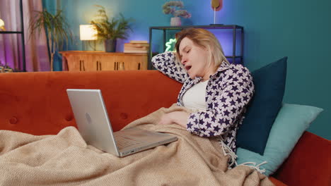 Bored-sleepy-young-Caucasian-woman-working-on-laptop-computer-falling-asleep-at-home-couch