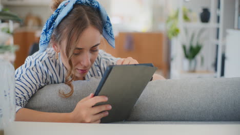 Woman-Enjoying-Internet-and-Social-Media-on-Digital-Tablet-at-Home