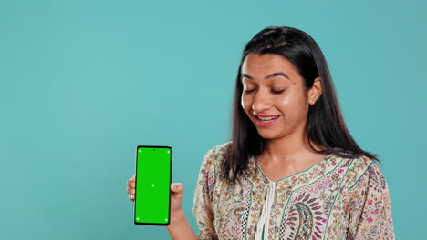 Woman-doing-influencer-marketing-using-green-screen-smartphone
