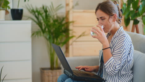 Woman-Writing-Emails-While-Drinking-Water