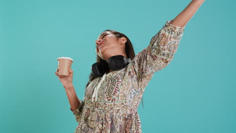 Joyful-woman-stretching-and-sipping-coffee-after-waking-up