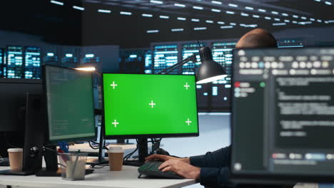 Technician-overseeing-server-room,-running-code-on-green-screen-computer