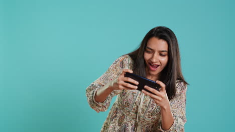 Happy-woman-playing-videogames-on-smartphone,-celebrating-after-win