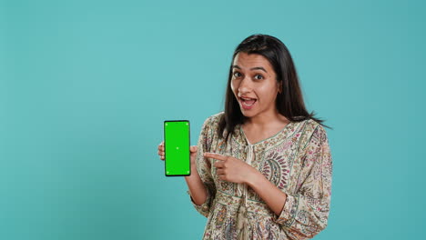 Mujer-Que-Presenta-El-Teléfono-Móvil-De-Pantalla-Verde.