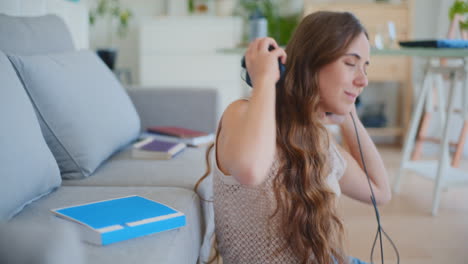 Woman-Closes-Book-Puts-on-Headphones-to-Relax-with-Music